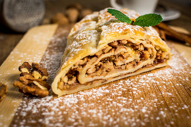 Traditional apple strudel or pie with walnuts and whipped cream