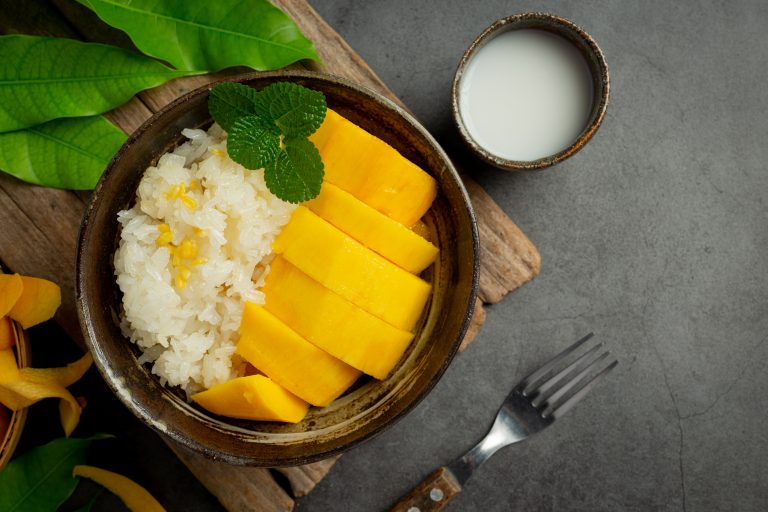 fresh ripe mango and sticky rice with coconut milk on dark backg