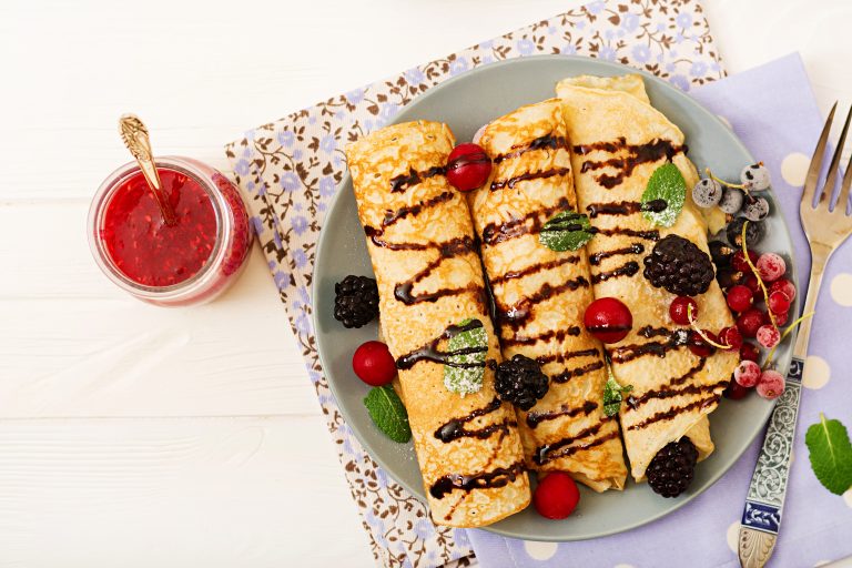 Pancakes with chocolate, jam and berries. Tasty breakfast. Flat lay